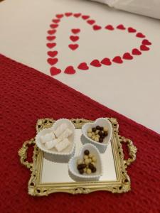 a plate with two hearts and two bowls of candy at Palácio Quitandinha Espetacular Apartamento com Vista para o Lago in Petrópolis