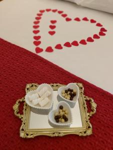 a plate with two hearts and two bowls of candy at Palácio Quitandinha Espetacular Apartamento com Vista para o Lago in Petrópolis +60 photos