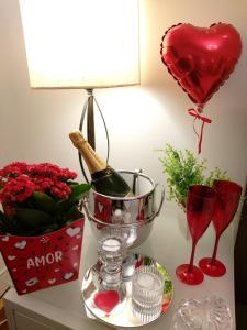 a table with a bottle of wine and a heart balloon at Palácio Quitandinha Espetacular Apartamento com Vista para o Lago in Petrópolis