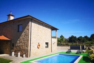 a house with a swimming pool next to a building at Casa Borlido in Ponte de Lima