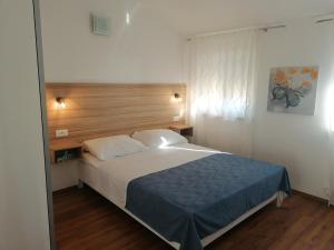 a bedroom with a large bed with a wooden headboard at Apartments Crikvenica in Crikvenica