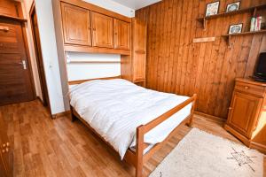 Dormitorio pequeño con cama y armarios de madera en Charming 50m With Balcony In Megève !, en Megève