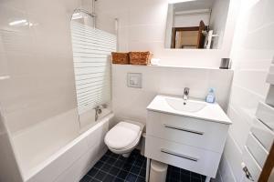 Baño blanco con aseo y lavamanos en Charming 50m With Balcony In Megève !, en Megève