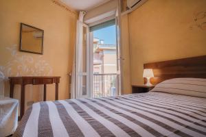 a bedroom with a bed and a large window at Villa Angela Olympic Garda Lake in Toscolano Maderno