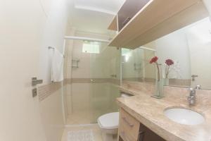 uma casa de banho com um WC, um lavatório e um chuveiro em Apartamento c/ hidromassagem 3 Suítes em Meia Praia em Itapema