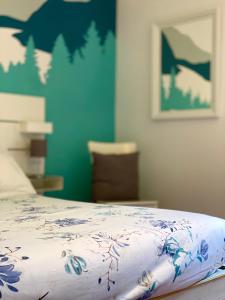 - un lit avec une couverture bleue et blanche dans l'établissement Enjoy Ledro B&B, à Ledro