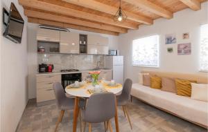 una cucina e un soggiorno con tavolo e divano di Cozy Home In Poljica With Kitchen a Poljica