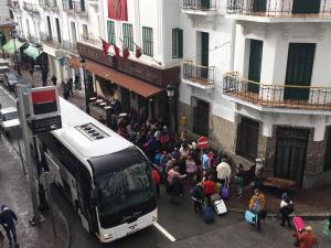 un grupo de personas parada frente a un autobús en HOTEL REGINA en Tetuán