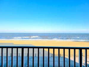 a view of the beach and the ocean from a balcony at Ocean Resort in Virginia Beach