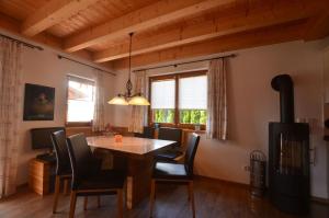 comedor con mesa y sillas en Feriendorf Via Claudia Haus 53 Alpenrose en Lechbruck