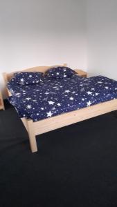 uma cama num quarto com um cobertor floral azul e branco em Casa Catalin em Gura Humorului