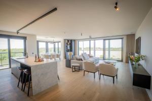 an open living room with a kitchen and a living room at Luxurious design appartement, 2 bedroom 4 person in Cadzand