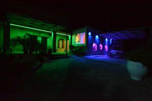 uma casa iluminada à noite com luzes verdes e roxas em Villa Olive Tree with Private Pool em Kissamos