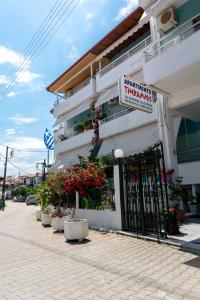 a sign on the side of a building with flowers at ΤΗΕRAMVOS in Pefkochori