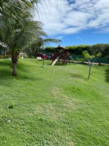 un parque infantil con una palmera en Fortaleza- Praia Beach Park Aptº Porto das Dunas, en Aquiraz