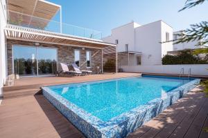 a swimming pool in the backyard of a house at Villa Aquamarine in Paphos City