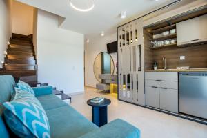 a living room with a blue couch and a kitchen at Elegant Corner in Limenaria