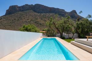 una piscina con una montagna sullo sfondo di Sea View White Villa a Stavros