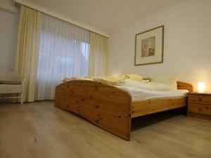 a bedroom with a wooden bed and a window at Ferienwohnung in Westerland auf Sylt in Westerland (Sylt) +24 photos