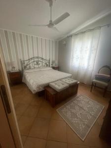 Schlafzimmer mit einem Bett und einem Fenster in der Unterkunft Casa vacanze Sant'Antioco in SantʼAntìoco