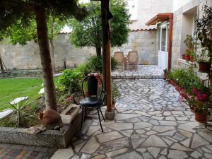 a stone patio with a chair in a yard at villa Tia Maria in Hisarya