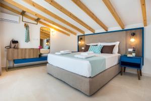 a bedroom with a large bed and a mirror at Elegant Corner Superior Rooms & Apartments in Limenaria