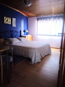 a bedroom with a bed and a table and a window at Casa, apartment dúplex independiente in O Grove