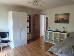 1 dormitorio con 1 cama, armario y silla en Albblick en Bad Herrenalb