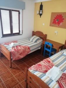 a room with three beds and a blue chair at lagos central hostel in Lagos