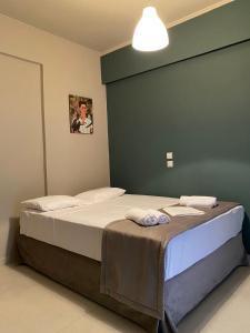 a bed in a bedroom with a green wall at MVP studios in Preveza +4 photos