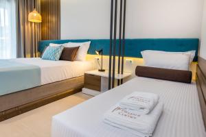 a hotel room with two beds with towels on them at Elegant Corner in Limenaria