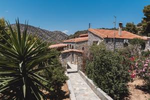 a stone house with a garden and a plant at Villa Angelos in Ermioni