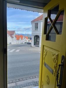 a yellow door with a view of a street at The yellow door in Stavanger