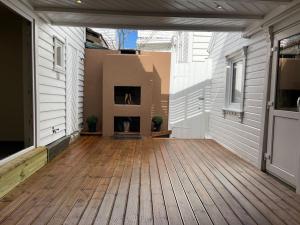 eine Veranda mit Holzböden und einem Kamin in der Unterkunft The yellow door in Stavanger