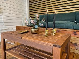a coffee table with three candles and a couch at The yellow door in Stavanger