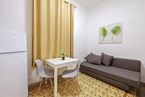ein kleines Zimmer mit einem Tisch und einem Sofa in der Unterkunft nearporto in Trapani