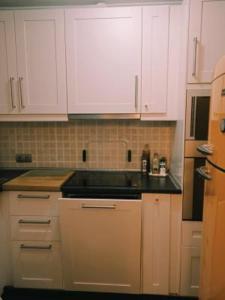 eine Küche mit weißen Schränken und einer schwarzen Arbeitsplatte in der Unterkunft Apartamento Sissi in Nerja