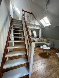 una escalera que conduce a una sala de estar con sofá en Le Pic Dînantais - Appartement cosy ✮, en Dinant