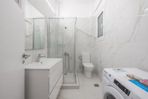 La salle de bains blanche est pourvue d'une douche et de toilettes. dans l'établissement Victoria Best Apartments, à Athènes