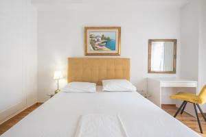 a bedroom with a large white bed and a chair at Victoria Secret Apartments in Athens