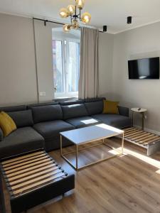 a living room with a black couch and a table at Apartamenty Dobranocka in Krotoszyn