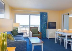 a living room with a couch and a table and a tv at Fantasy Island II in Daytona Beach Shores
