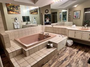 a large bathroom with a tub and two sinks at Golfside Vacation Home 2 in Bella Vista