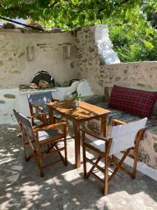 een houten tafel en stoelen en een bank met een open haard bij Sergios Village House in Chania