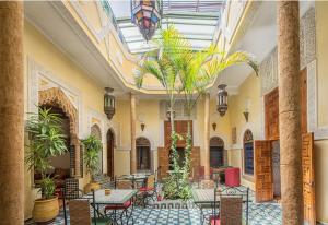 una habitación con mesas y sillas en un edificio en Riad Dar Zouhour, en Rabat