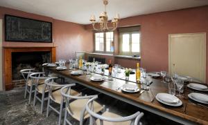 uma sala de jantar com uma mesa longa e cadeiras em Topside House - Beautiful 7 bedroom house with hottub wifi and parking near Bath Wells Frome em Oakhill