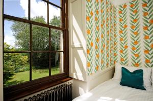 1 dormitorio con cama y ventana en Topside House - Beautiful 7 bedroom house with hottub wifi and parking near Bath Wells Frome, en Oakhill