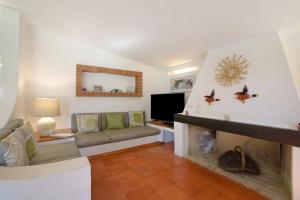 salon z kanapą i kominkiem w obiekcie Quinta da Balaia w Albufeirze