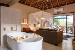 un soggiorno con vasca e una camera da letto di Moya Safari Lodge & Villa a Hoedspruit