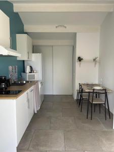 a kitchen with a table and a dining room at « La Parenthèse » gîte en Camargue in Arles